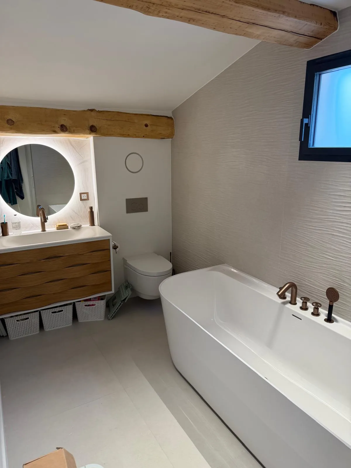 Salle de bain sous poutres avec baignoire îlot